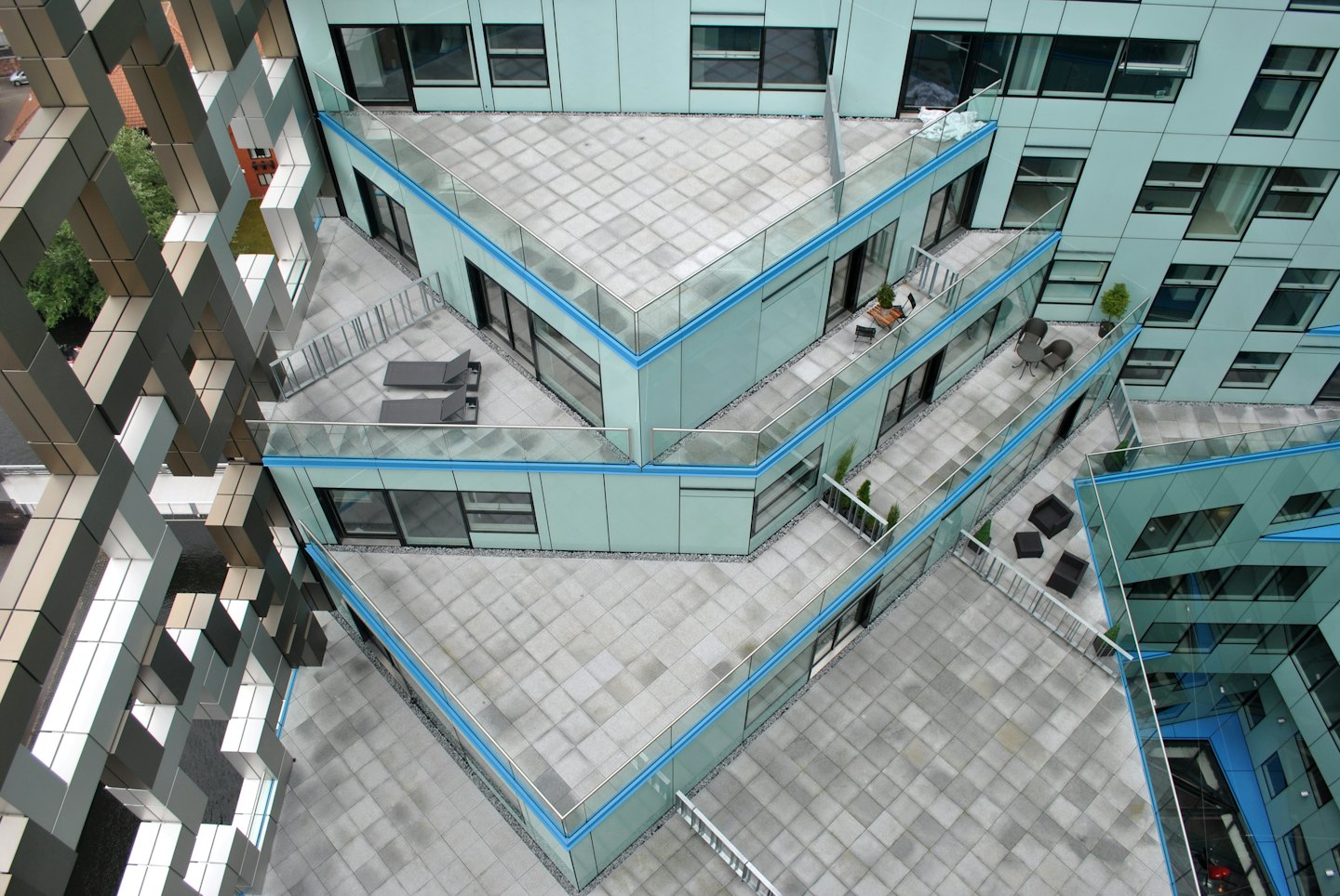 Moderna balkonger med lounge-möbler och geometrisk fasad.